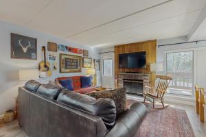 Una sala de estar con un sofá de cuero y un televisor. en 5A Mountain Village - Unit A, en Dover