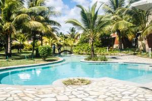 a swimming pool in a resort with palm trees at Toi Et Moi in Bain Boeuf