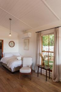 une chambre avec un lit, une chaise et une fenêtre dans l'établissement Olyf guestcottage, à Bloemfontein