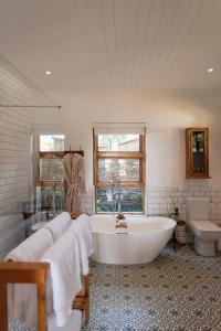 une salle de bain avec une baignoire, des toilettes et un lavabo dans l'établissement Olyf guestcottage, à Bloemfontein
