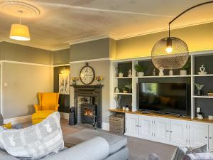 a living room with a tv and a fireplace at Cracken Cottage - Uk48297 in Chinley