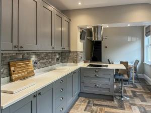 a kitchen with white cabinets and a counter top at Cracken Cottage - Uk48297 in Chinley +16 photos