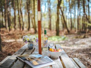 a bottle of wine and a bowl of fruit on a picnic table at Chere Amie-Qu7616 in Melton Constable