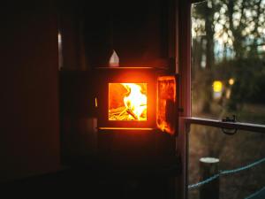 a fire burns in a glass box in a window at Chere Amie-Qu7616 in Melton Constable +20 photos