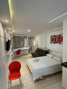 ein Schlafzimmer mit einem Bett, einer Couch und einem Fernseher in der Unterkunft Apartamento em Intermeares | Quarto Casal Estúdio in Ilha da Restinga