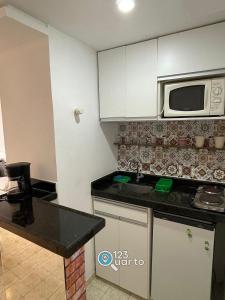 eine Küche mit Spüle und Mikrowelle in der Unterkunft Apartamento em Intermeares | Quarto Casal Estúdio in Ilha da Restinga
