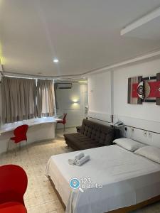 ein Hotelzimmer mit einem Bett und einer Couch in der Unterkunft Apartamento em Intermeares | Quarto Casal Estúdio in Ilha da Restinga