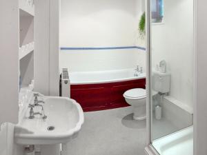 a bathroom with a tub and a sink and a toilet at The Bungalow in Saint Ishmaels