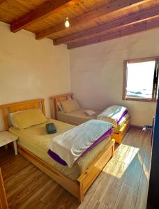two twin beds in a room with a window at beachfront house in Taghazout