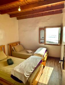 two beds in a room with a window at beachfront house in Taghazout