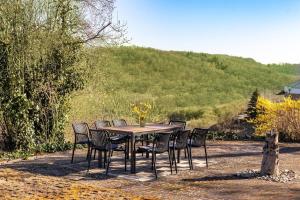 een tafel en stoelen rond een tafel met een heuvel bij Living between heaven and forest in Bermel