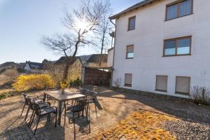 een terras met een tafel en stoelen voor een gebouw bij Living between heaven and forest in Bermel