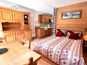 ein Schlafzimmer mit einem Bett und einem Tisch darin in der Unterkunft Studio Esprit Montagne pour 4 personnes, Vue sur le Borne - FR-1-458-106 in Le Grand-Bornand