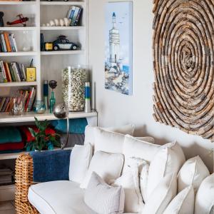 een woonkamer met een witte bank en een boekenplank bij SableChateau Beachfront Guesthouse in Stompneusbaai