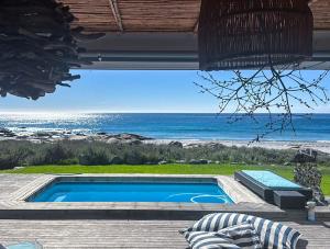 een zwembad met uitzicht op de oceaan bij SableChateau Beachfront Guesthouse in Stompneusbaai