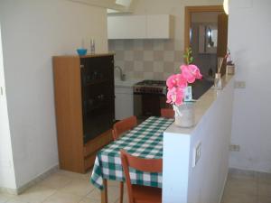una cocina con una mesa con un jarrón de flores. en Appartamento Mariana, en Matera