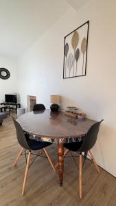 a wooden table with two chairs in a room at Appartement confort deux Etoiles in Dole +26 photos