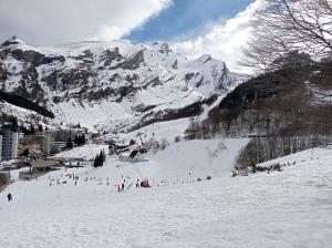 a group of people skiing down a snow covered mountain at Les Epicuriens in Bielle