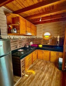 a kitchen with wooden cabinets and a stainless steel refrigerator at beachfront house in Taghazout