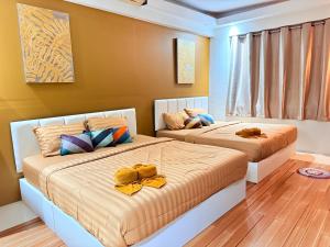 two beds in a bedroom with yellow walls at Koh Chang Pool Villa Viewthalay in Ko Chang +62 photos