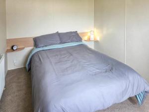 a bedroom with a large bed with blue sheets at Waterlily in Lancaster