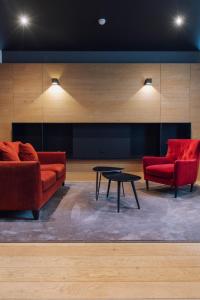 two red chairs and a table in a room at Domaine des Terres du Val in Wanze