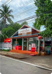een winkel aan de kant van een straat met een bord bij Infinity Blue, High Speed Wi-Fi, Soft bed in Udon Thani +17 foto's