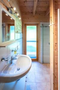 - une salle de bains avec lavabo dans une maison en bois dans l'établissement Wellness-Chalet am Badesee für bis zu 10 Personen, à Rieden 53 autres photos