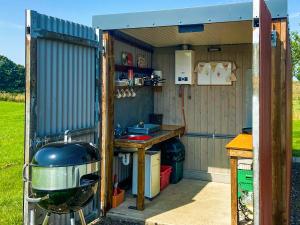 eine Küche in einem Schuppen mit einer Theke in der Unterkunft Shepherds Cottage - Uk49766 in Northampton