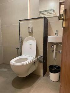 a bathroom with a white toilet and a sink at Hotel Emora Tree in Mysore +25 photos