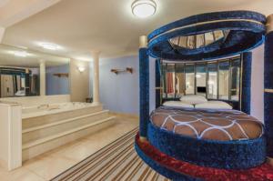 una camera con letto blu e vasca da bagno di Mount Pleasant INN a Mount Pleasant