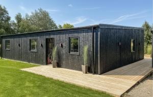 a black tiny house with a wooden deck at Awesome Home In Vinderup With Sauna in Vinderup