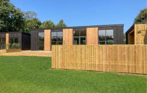 a house with a wooden fence in front of a yard at Awesome Home In Vinderup With Sauna in Vinderup