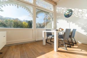 a dining room with a table and chairs and windows at Appartement Baltic Pearl in Ostseebad Sellin +13 photos