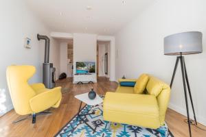 a living room with two yellow chairs and a rug at Appartement Baltic Pearl in Ostseebad Sellin