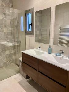 ein Badezimmer mit Waschbecken, Spiegel und Dusche in der Unterkunft Ty Pals in Pals