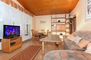 uma sala de estar com um sofá e uma TV de tela plana em Ferienhaus Blauer Anker em Bensersiel