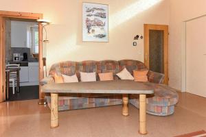 uma sala de estar com um sofá e uma mesa em Ferienhaus Blauer Anker em Bensersiel