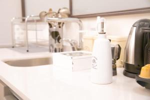 a white bottle of soap sitting on a kitchen counter at Spacious Loft in Rome Jewish Ghetto in Rome
