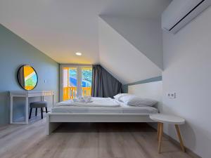 a bedroom with a bed and a table and a window at Aranypart Camping & Apartments in Siófok