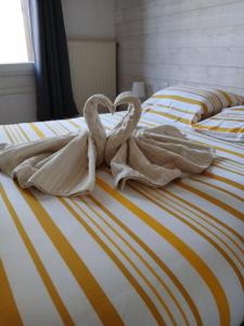 two swans are sitting on top of two beds at T2 avec terrasse privative in Le Havre