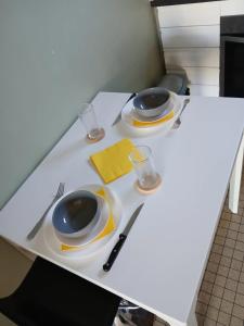 a table with plates and utensils on it at T2 avec terrasse privative in Le Havre +1 photo