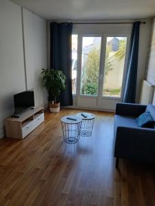 a living room with a blue couch and a tv at T2 avec terrasse privative in Le Havre