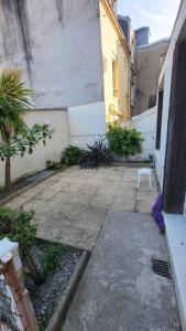a small courtyard with a white chair in a building at T2 avec terrasse privative in Le Havre
