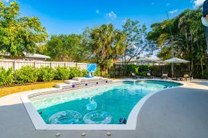 ポンパノビーチにあるVilla Heated Pool, Arcade games 5 min Beachの椅子とフェンスのある庭のスイミングプール