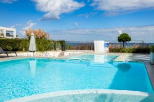 a large swimming pool with blue water and chairs at Selena Beach Family Hotel - All Inclusive Light in Sozopol