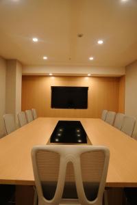 Sala de conferencias con mesa grande y TV en Rek Holiday Hotel, en Erbil