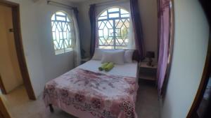 马埃堡Mahebourg Paradise Residence的一间卧室,床上有一只绿色的填充动物