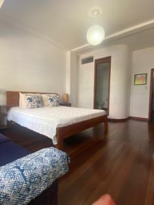 a bedroom with a bed and a wooden floor at Casa Hotel Jardin Azul in Cali