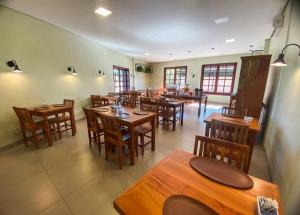 a restaurant with wooden tables and wooden chairs at Estância Hotel in Jardim